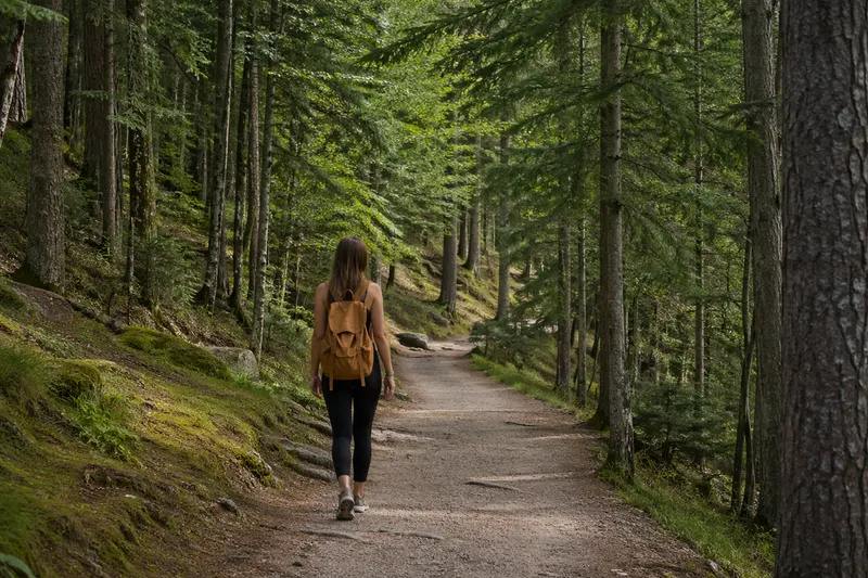 Donna che cammina su un sentiero nel bosco